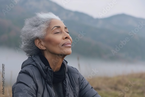 African woman enjoying the fresh morning air on the mountain, calming refreshing