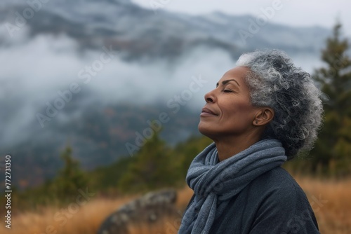 African woman enjoying the fresh morning air on the mountain, calming refreshing