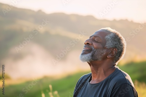 African man enjoying the fresh morning air on the mountain, calming refreshing