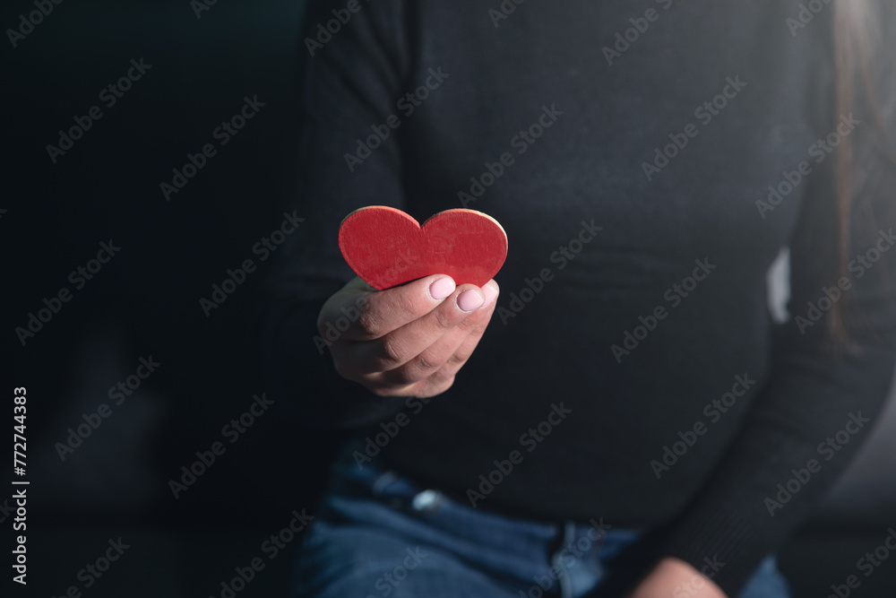 Caucasian young woman showing red heart. Caucasian young woman showing red heart.