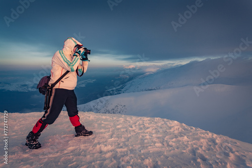 Photographer takes picture of great sunrise in the Carpathian mountains. Dramatic winter scene of the top of Dragobrat ski resort. Traveling concept background..