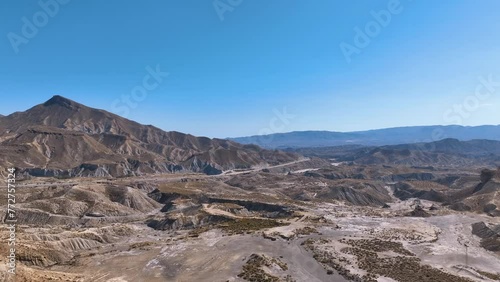 Aerial pans Tabernas desert with far views towards Almeria city via A92 photo