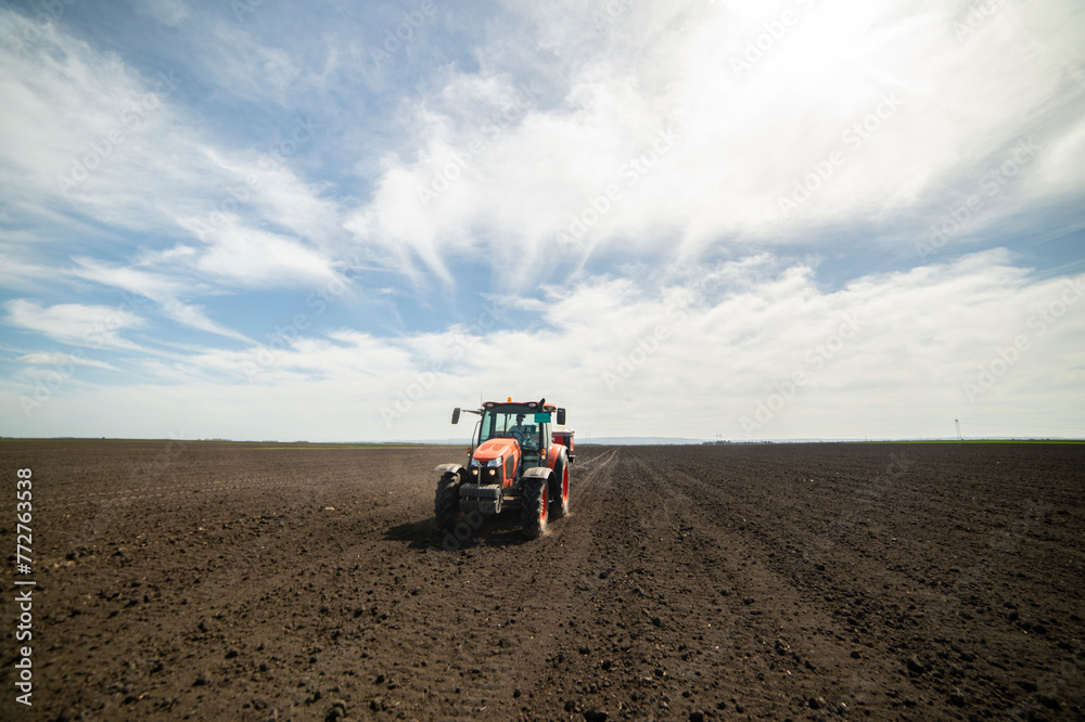 Obraz premium Tractor spreading artificial fertilizers