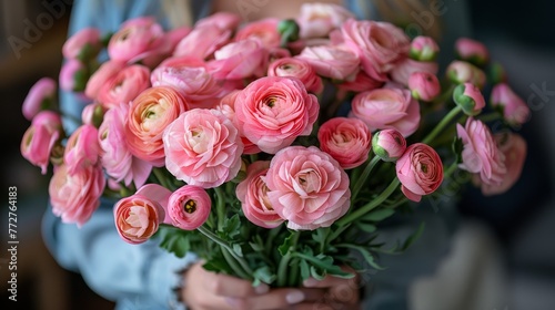  Close-up portrait of a person cradling a bouquet of pink flowers with dewed petals