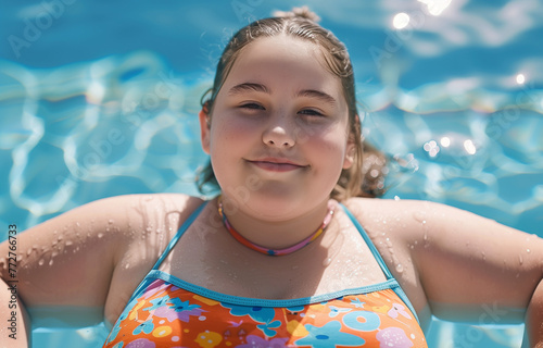 normal chubby happy girl in pool on vacation smiling in the sun