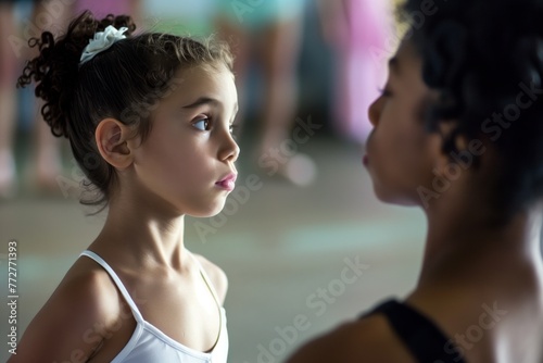young ballerina looking expectantly at instructor