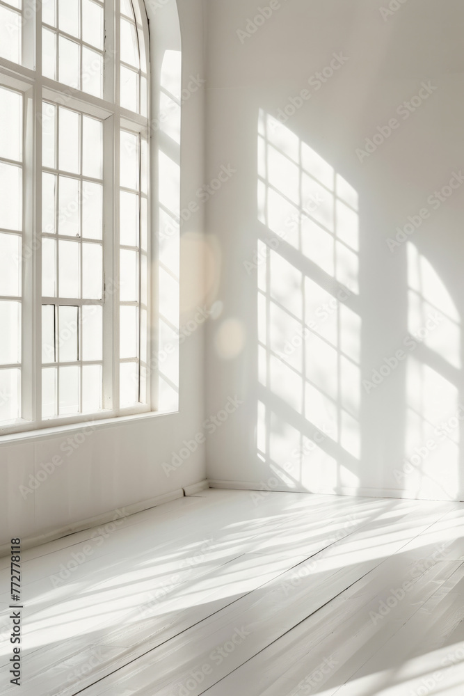 Fototapeta premium White minimalistic room with blank walls and sunlight streaming through windows. Creating a background of sun rays and shadows