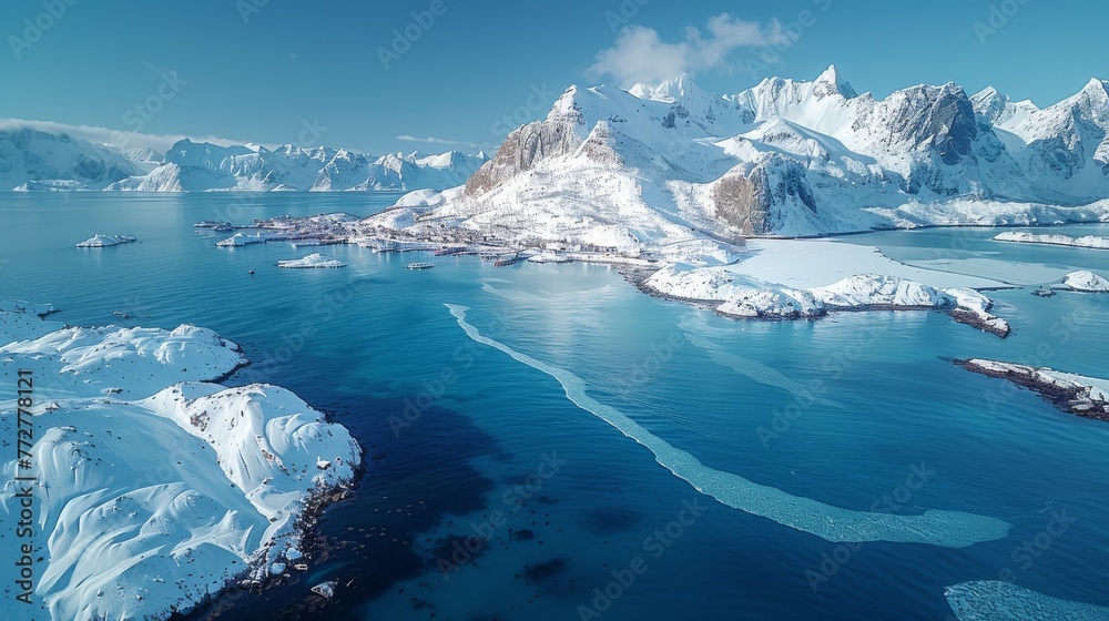   An aerial shot of a vast expanse of water encircled by snowcapped peaks and frozen icebergs