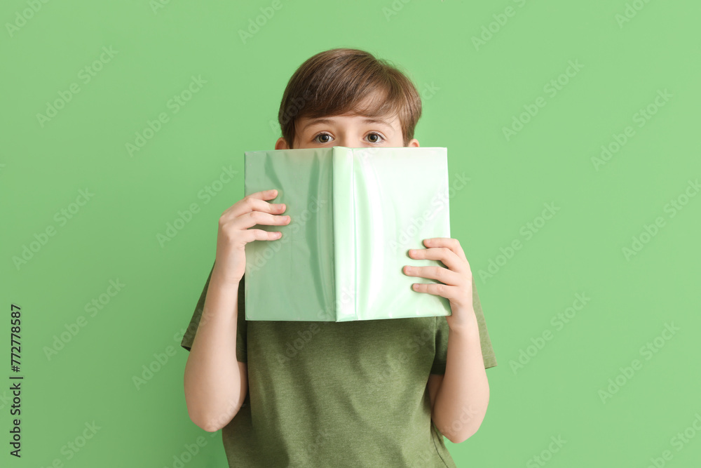 Little boy with book on green background. Children's Day celebration Little boy with book on green background. Children's Day celebration
