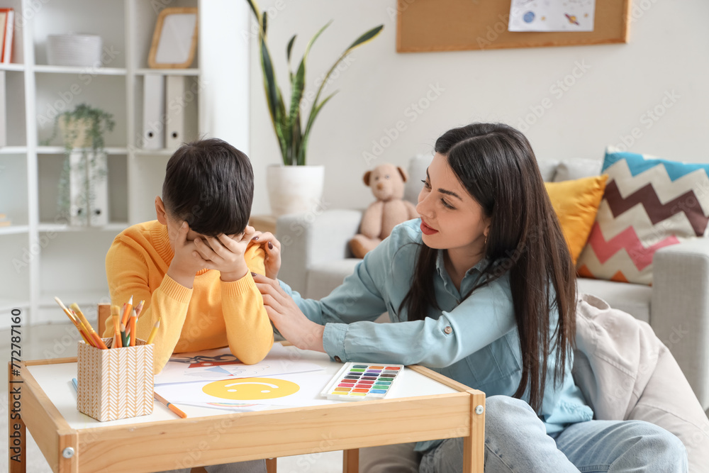 Female psychologist with crying little boy in office Female psychologist with crying little boy in office