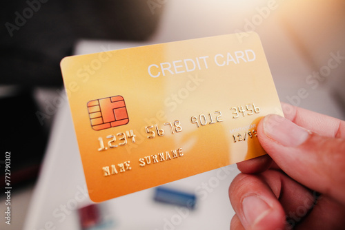 Mockup of yellow credit card in hand with sunlight , Credit or debit card financial concept