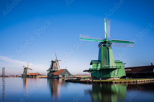 a row of windmills on the water in