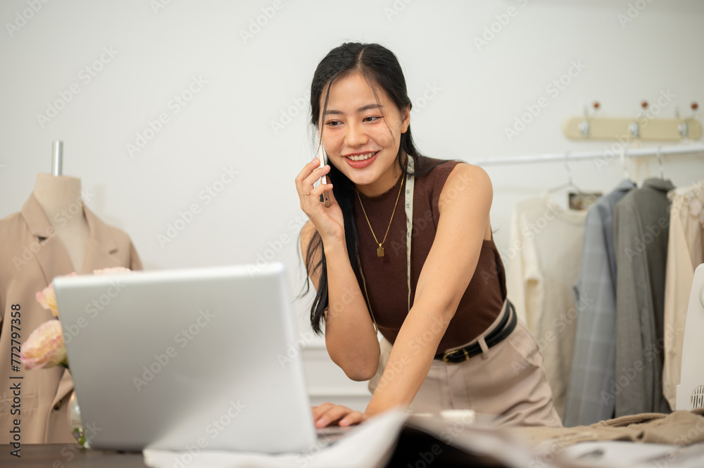 A professional, busy female tailor is talking on the phone with while working in her studio. A professional, busy female tailor is talking on the phone with while working in her studio.