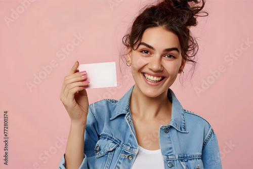 A young woman in a denim shirt holding a business card 