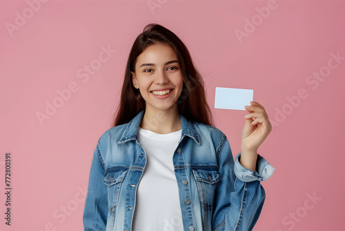A young woman in a denim shirt holding a business card 