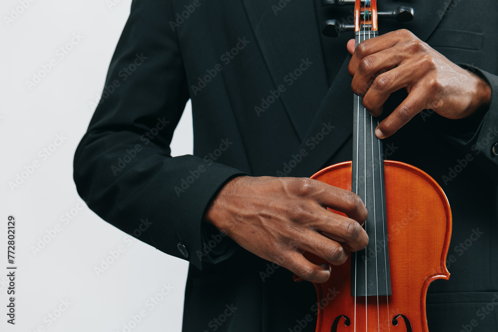 Closeup of a man in a suit playing a violin against a white background, classical music performance concept Closeup of a man in a suit playing a violin against a white background, classical music performance concept