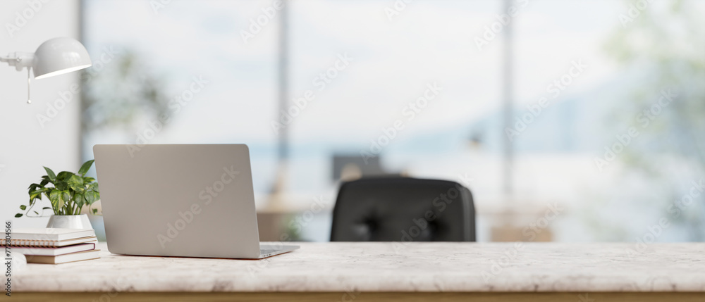 A back view image of a laptop computer on a white marble desk in a modern spacious office. - obrazy, fototapety, plakaty 