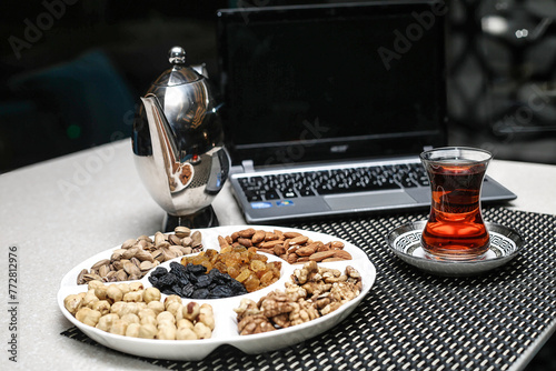 Plate of Assorted Nuts Next to a Cup of Tea © uhdenis