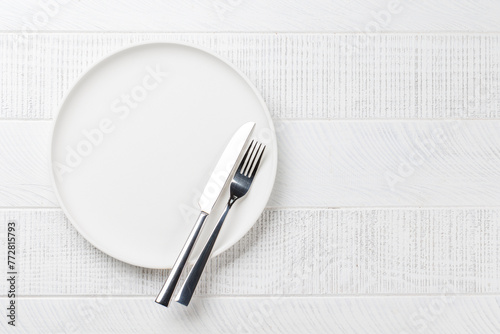Empty plate on wooden table, overhead view © karandaev