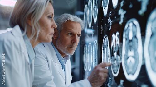 Up-close photo of knowledgeable medical experts in white coat examining complete body imaging on x-ray, CT scan, and MRI with isolated hospital clinic in the background. Department of radiology.