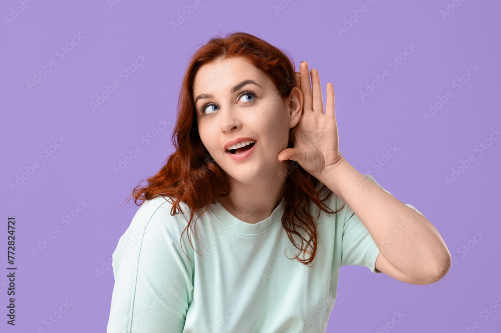 Beautiful young redhead woman showing eavesdrop gesture on lilac background Beautiful young redhead woman showing eavesdrop gesture on lilac background