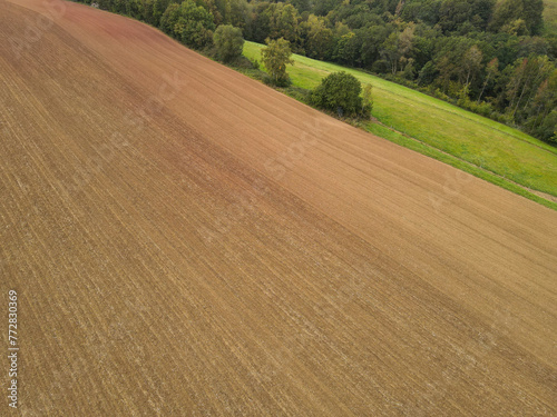 Aerial view of a brown plowed agriculture field with soil 