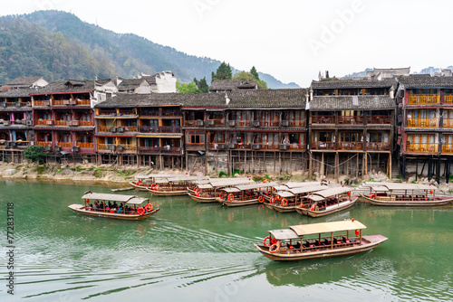 Feng Huang Ancient Town (Phoenix Ancient Town) and tourist boats on Tuo Jiang River, The famous tourist destination at Hunan Province, China © Kittiphan