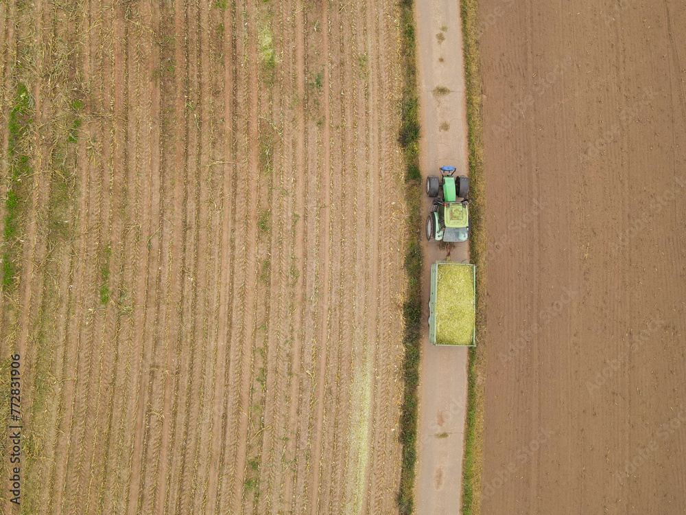 Aerial view of a tractor with a trailer in the countryside Aerial view of a tractor with a trailer in the countryside