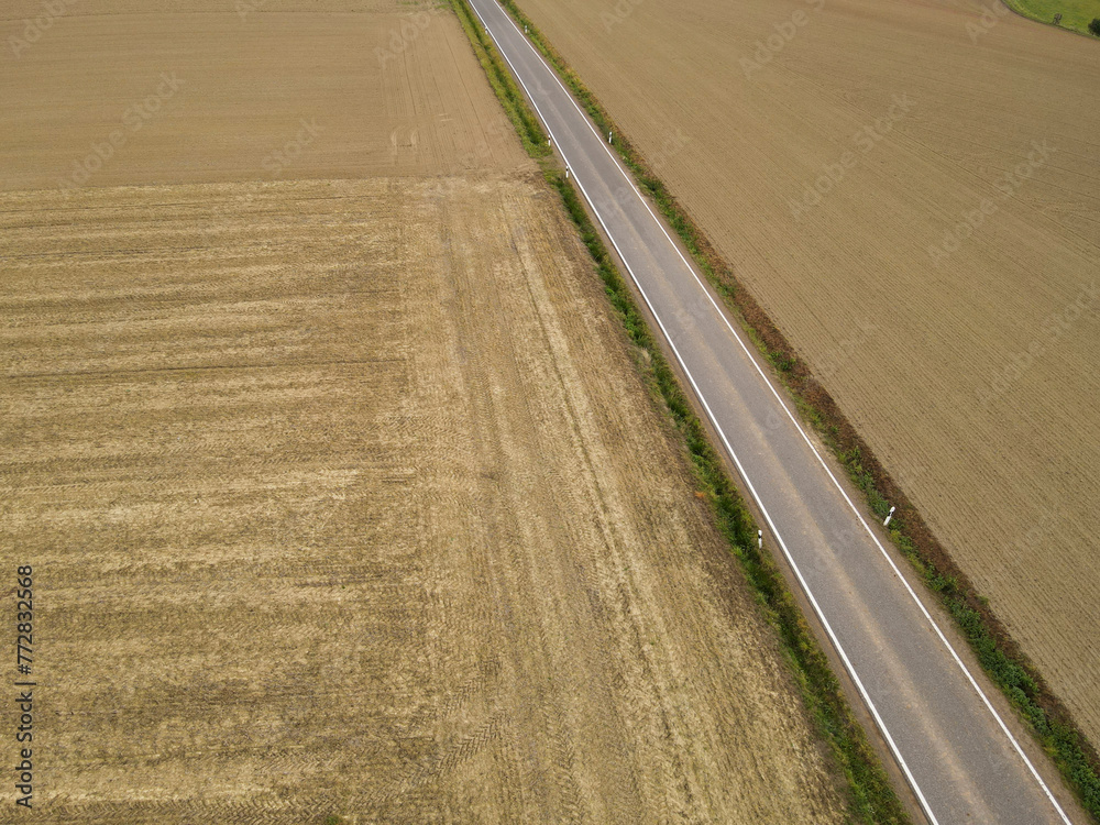 Aerial view of a asphalt road between farm fields in the countryside Aerial view of a asphalt road between farm fields in the countryside