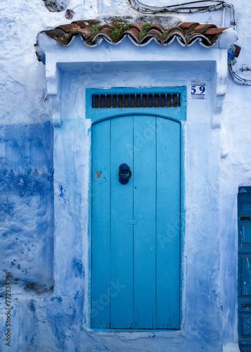 close-up view of a house front and door in the historic city center of the blue city of Chefchaouen in northern Morocco © makasana photo