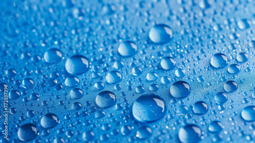 Panoramic view of water droplets on vibrant blue background