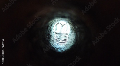 Billede på lærred Used dark round and long sewage, sewer or drainage tunnel water pipe hole with industrial dirty liquid impurity inside flowing towerds open end bokeh light