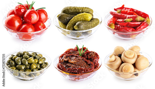 Glass bowls with pickled champignons, cucumbers, tomatoes, capers, chili pepper and sun dried tomatoes isolated on white background. Collection with clipping path.