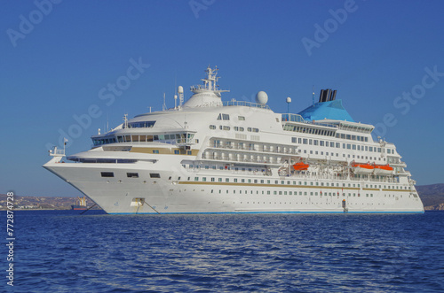 Small classic luxury cruiseship cruise ship liner yacht anchoring on Aegean blue sea in front of Milos Island during summer Mediterranean Greek isles cruising
