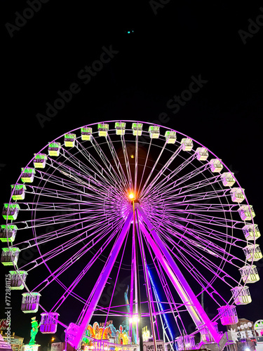 Amusement park at night - ferris wheel in motion. Concept of holiday people and have fun. Nightlife vacation.