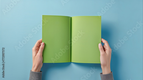 Hand holding blank brochure booklet or book mockup on blue background. Woman showing offset paper. Leaflet mock up holding hand. Booklet template. A5 paper sheet display read first person	 photo