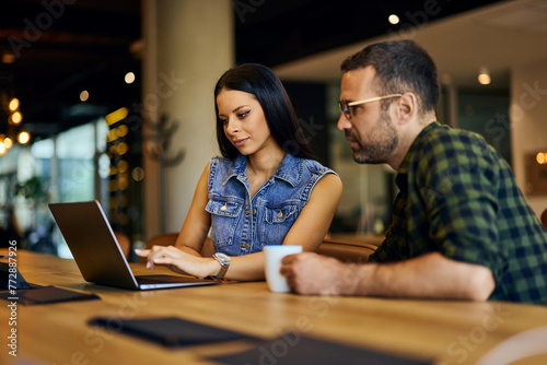 Businessman and businesswoman working together online, at the office.