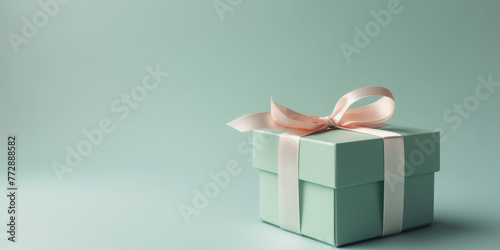 Gift box. Elegant green present box with white bow on a green pastel background, copy space. Beautiful Background for greeting card for Birthday, Mother's Day, Wedding, Valentine's Day