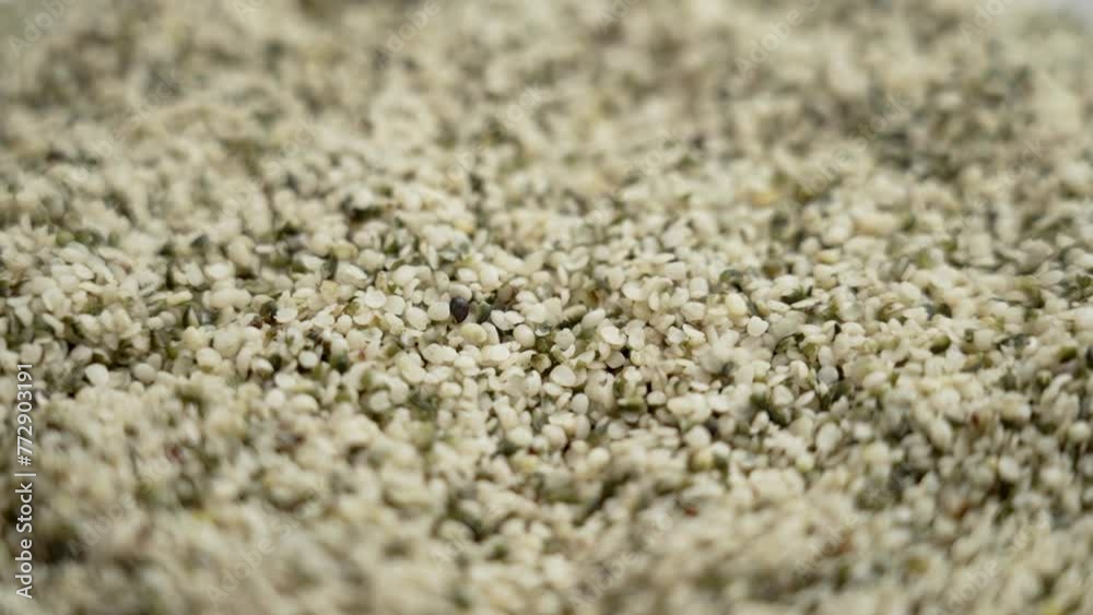 Hulled hemp seeds falling in slow motion. Alimentary food supplement close up. Rotation Hulled hemp seeds falling in slow motion. Alimentary food supplement close up. Rotation