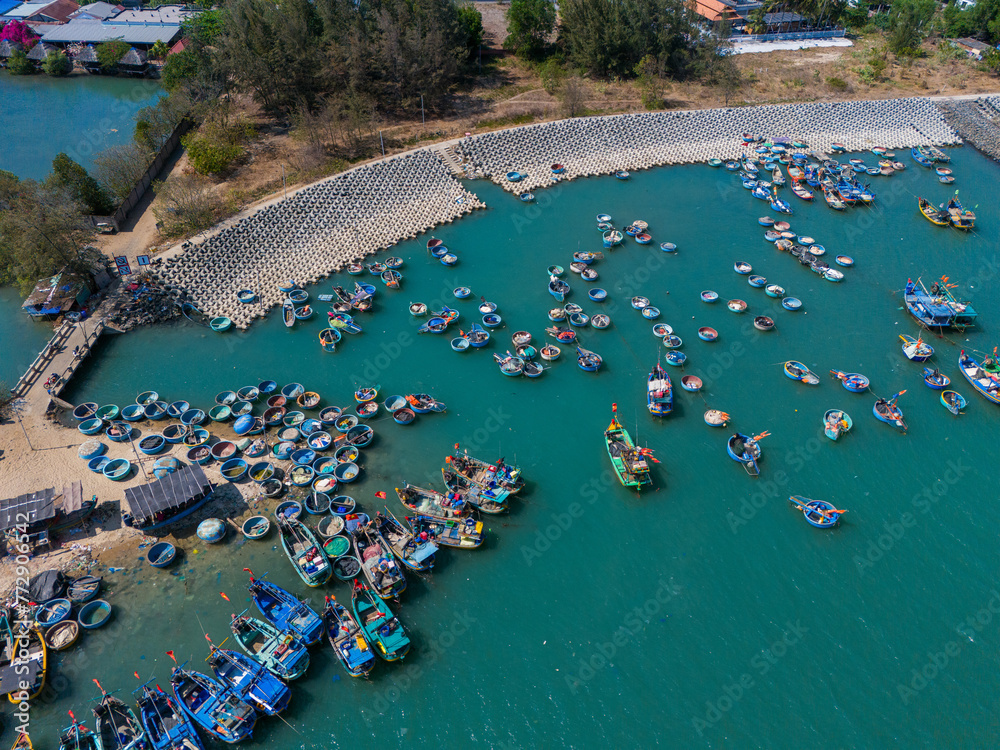 Aerial view of Loc An fishing village, Vung Tau city. A fishing port with tsunami protection concrete blocks. Cityscape and traditional boats in the sea.