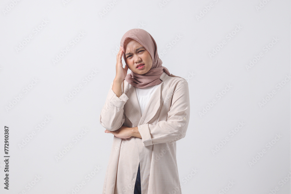 Portrait of overwhelmed Asian hijab woman in casual suit touching her head, having headache, and feeling stressed. Businesswoman concept. Isolated image on white background Portrait of overwhelmed Asian hijab woman in casual suit touching her head, having headache, and feeling stressed. Businesswoman concept. Isolated image on white background