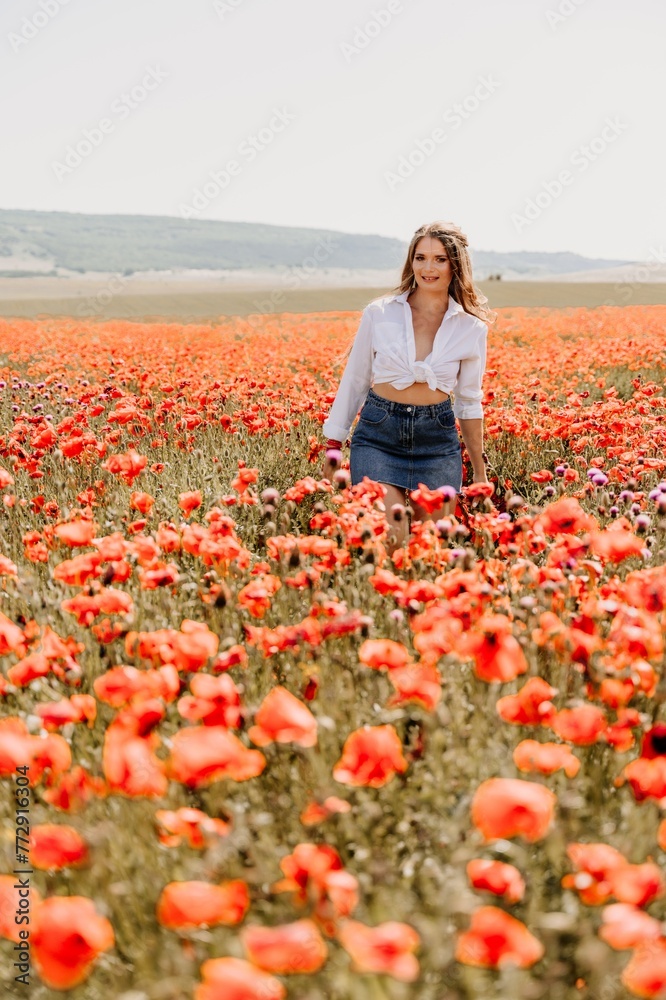 Happy woman in a poppy field in a white shirt and denim skirt with a wreath of poppies on her head posing and enjoying the poppy field. Happy woman in a poppy field in a white shirt and denim skirt with a wreath of poppies on her head posing and enjoying the poppy field.