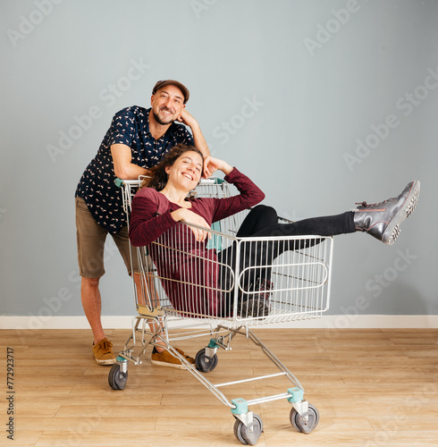 Happy Man and Woman osing for a Photo in a Shopping Cart at Home photo