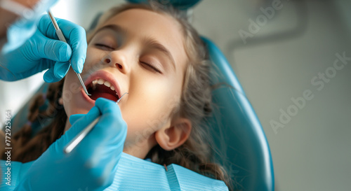 Pediatric dentistry. Little girl siting in a stomatology seat having a tooth examination by a pediatric stomatologist. Dental treatment. A close-up view of the child's face, bokeh