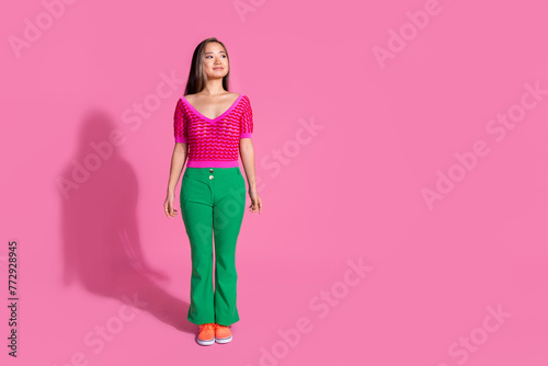 Full length photo of cheerful dreamy lady dressed knitted shirt walking loking empty space isolated pink color background photo