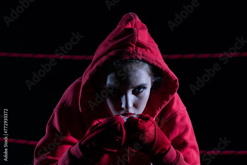 The athlete sits in a chair in the boxing ring after losing the fight. Despite the technical preparation, the athlete lost the fight in a sweatshirt. © fotodrobik