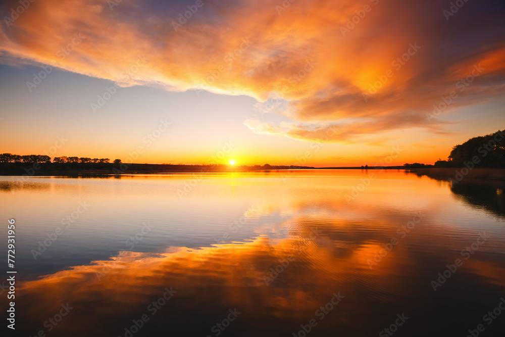 Attractive view of the sunset over the calm surface of the water.