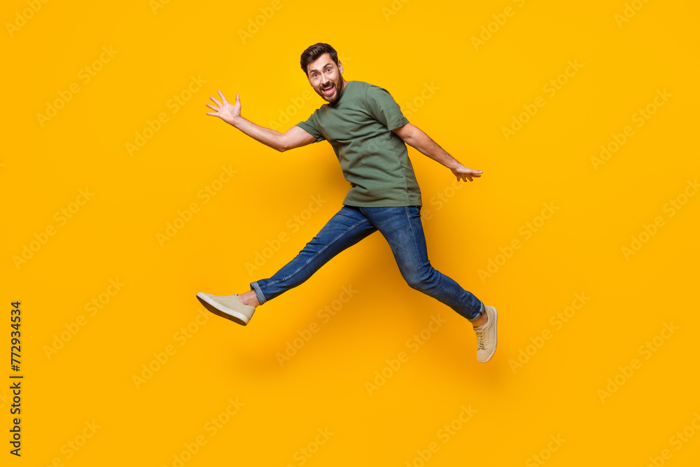 Full length photo of nice young male jump running fast dressed stylish khaki garment isolated on yellow color background