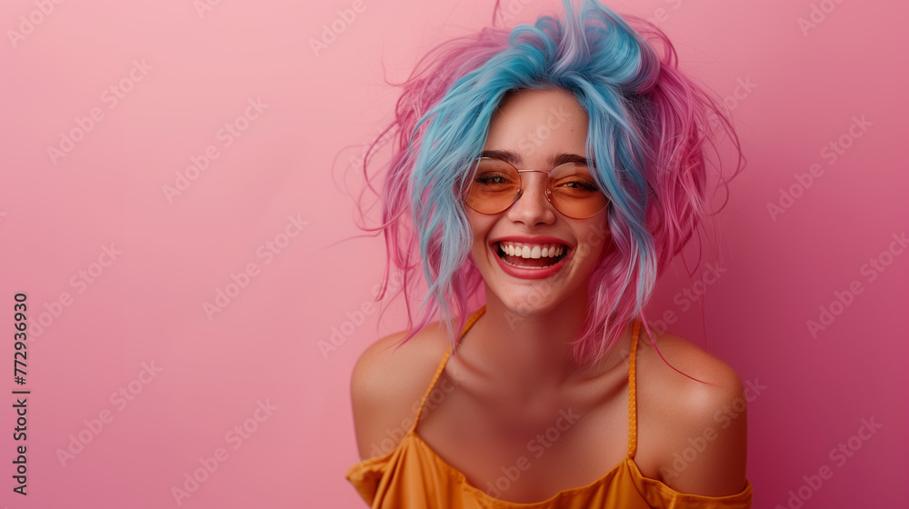 Woman with pink and blue hair laughing on a pink background.