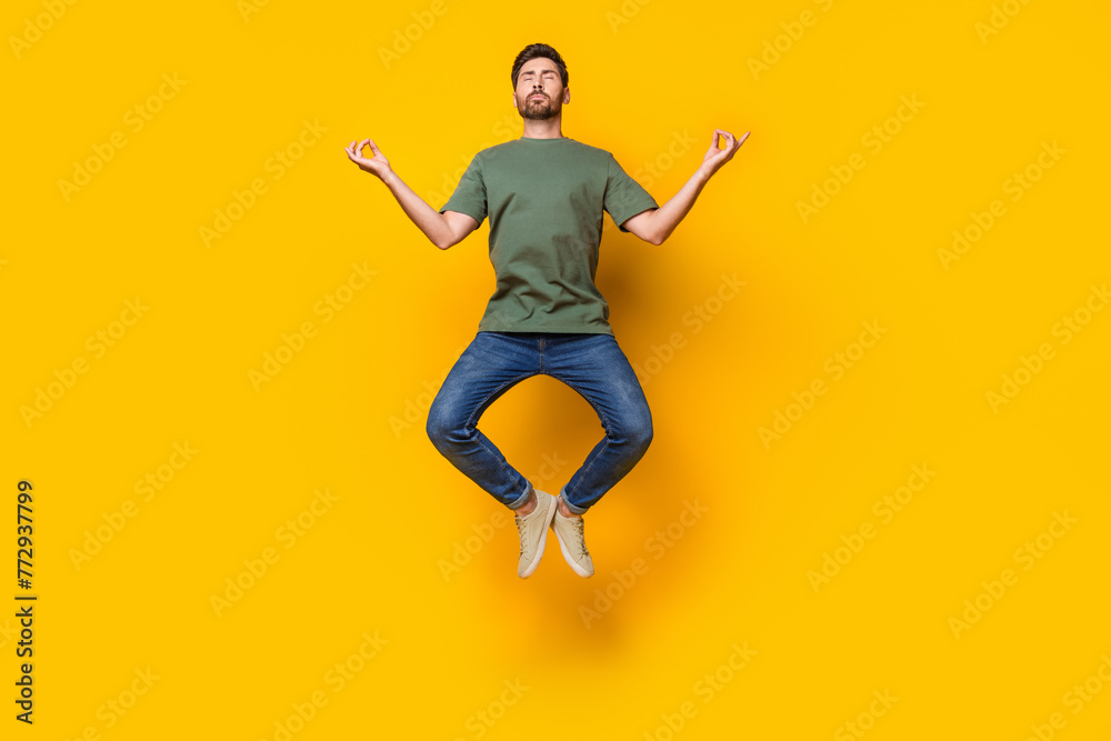 Full length photo of nice young male jump fly meditate stay calm dressed stylish khaki garment isolated on yellow color background